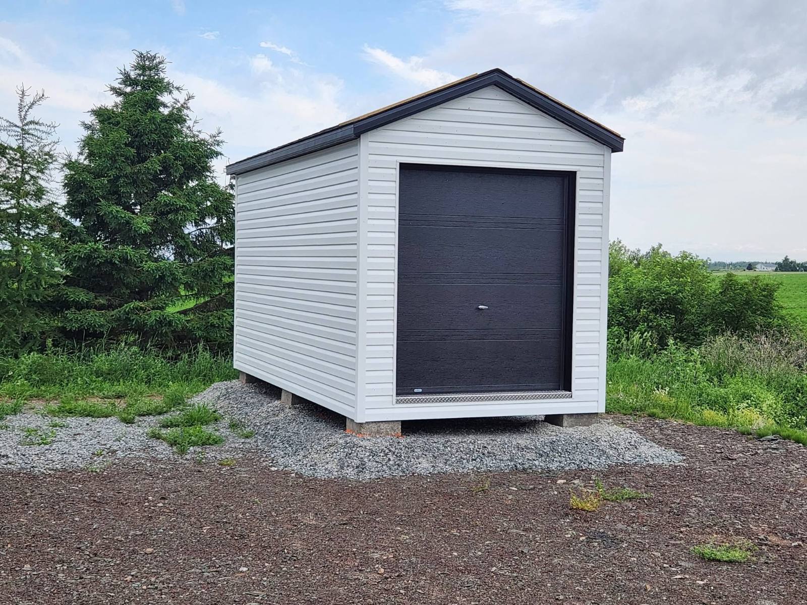 Cabanon blanc à porte de garage noire